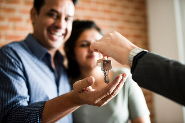 Excited couple receiving keys to their new home